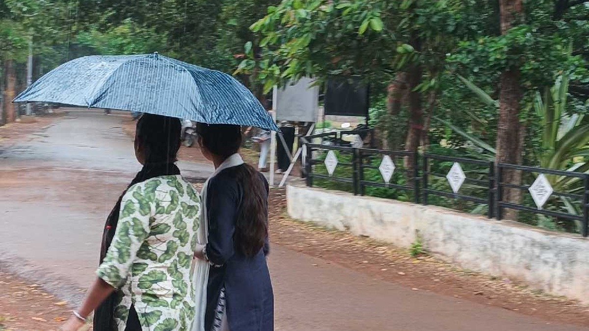 Dhamtari college students in rain carrying an umbrella
